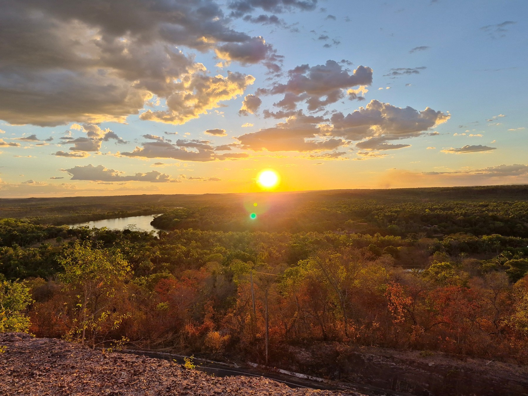 Pôr do sol dourado sobre a paisagem e o rio, fotografado por Pedrina